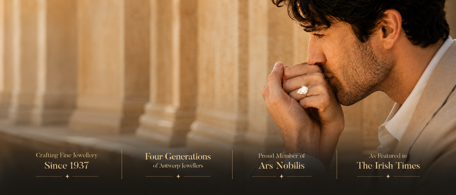A man in a white shirt stands in front of warm-toned stone columns, wearing a ring on his finger. Text banners at the bottom read 'Crafting Fine Jewellery Since 1937', 'Four Generations of Customary Jewellery', 'Proud Member of Ars Nobilis', and 'No Honesty in The Irish Times'.